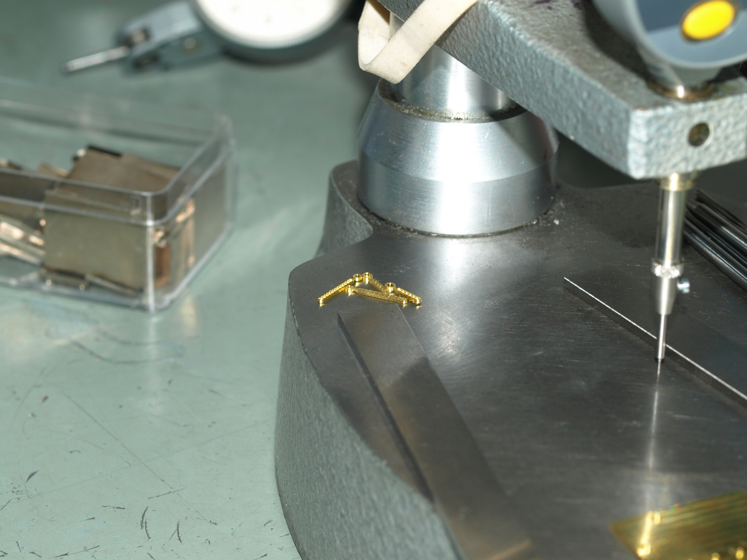 Gold watch hands ready to go to quality control and finishing departments