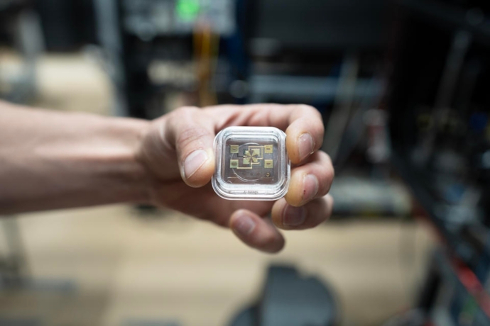 NIST physicist David Hume holds the newly modified ion trap for the aluminum ion clock. By modifying the trap, the aluminum ion and its magnesium ion partner were able to “tick” unperturbed. Credit: R. Jacobson/NIST